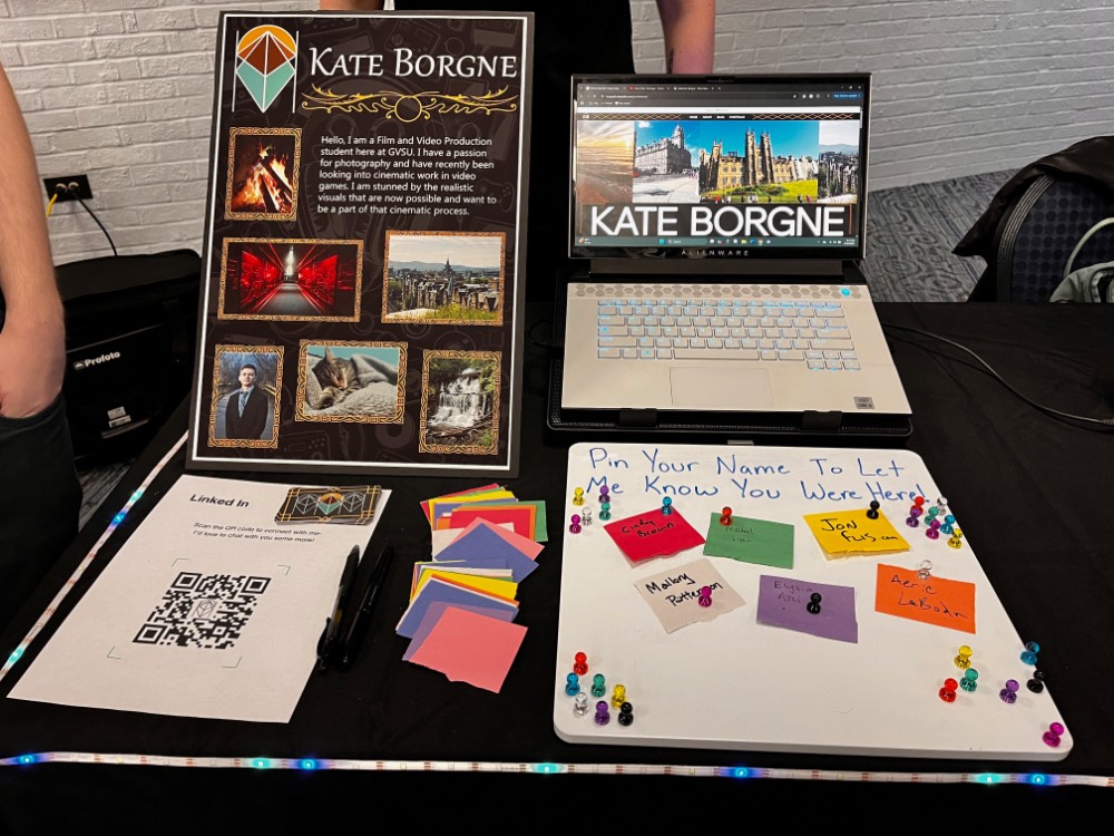 White board that says "Pin your name to let me know you were here!" with colorful paper held on with a magnet at Kate Borgne's table.